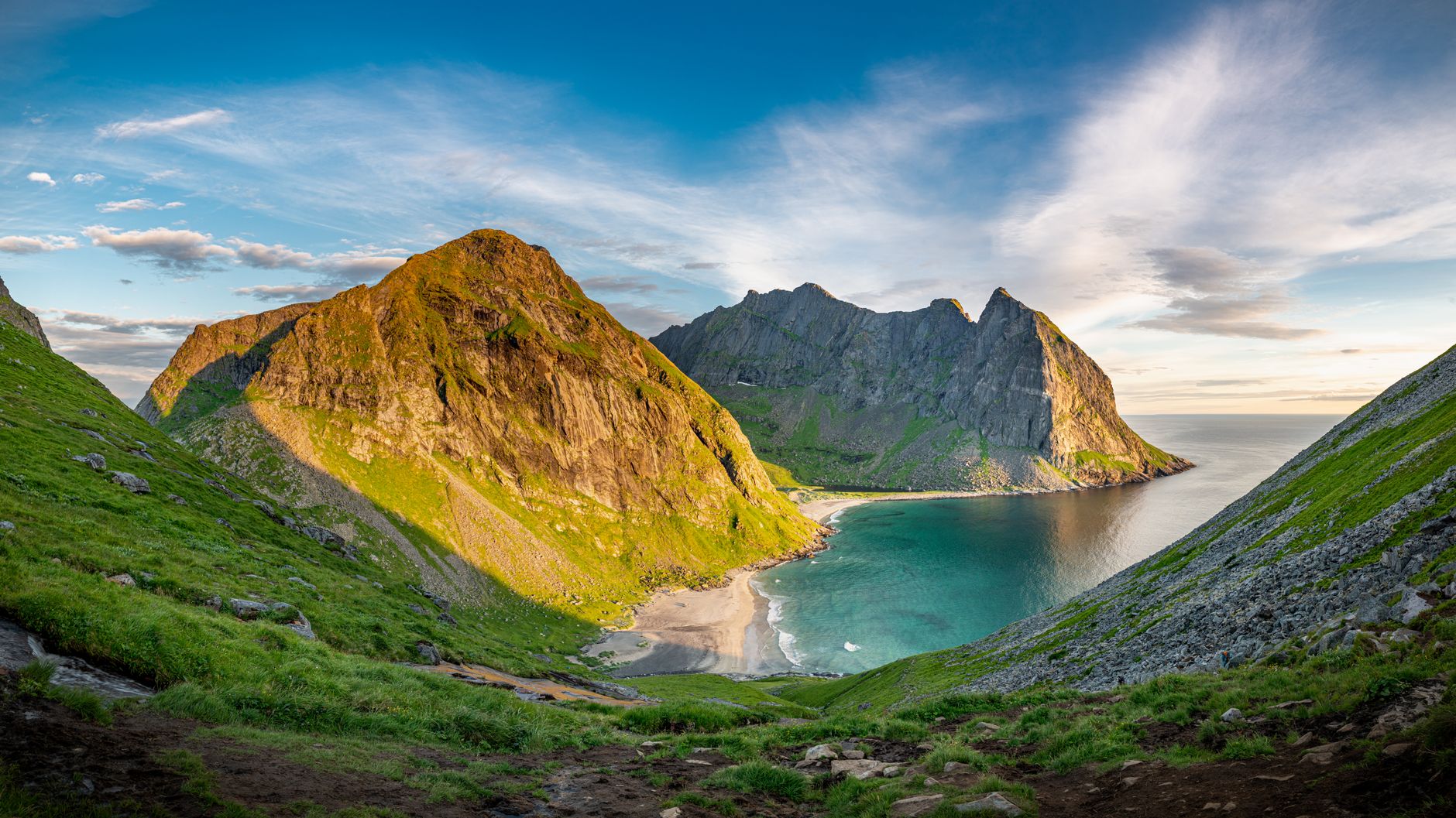 A breathtaking view of Kvalvika Beach surrounded by majestic mountains in Moskenes, Norway.