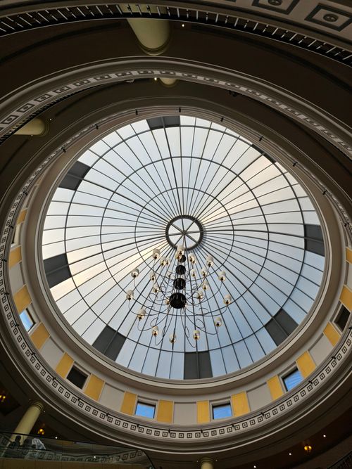 Free Intricate glass dome skylight with a grand chandelier in a stylish atrium. Stock Photo