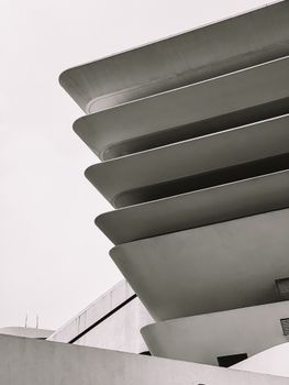 Abstract view of a modern building's facade with layered curves in monochrome.