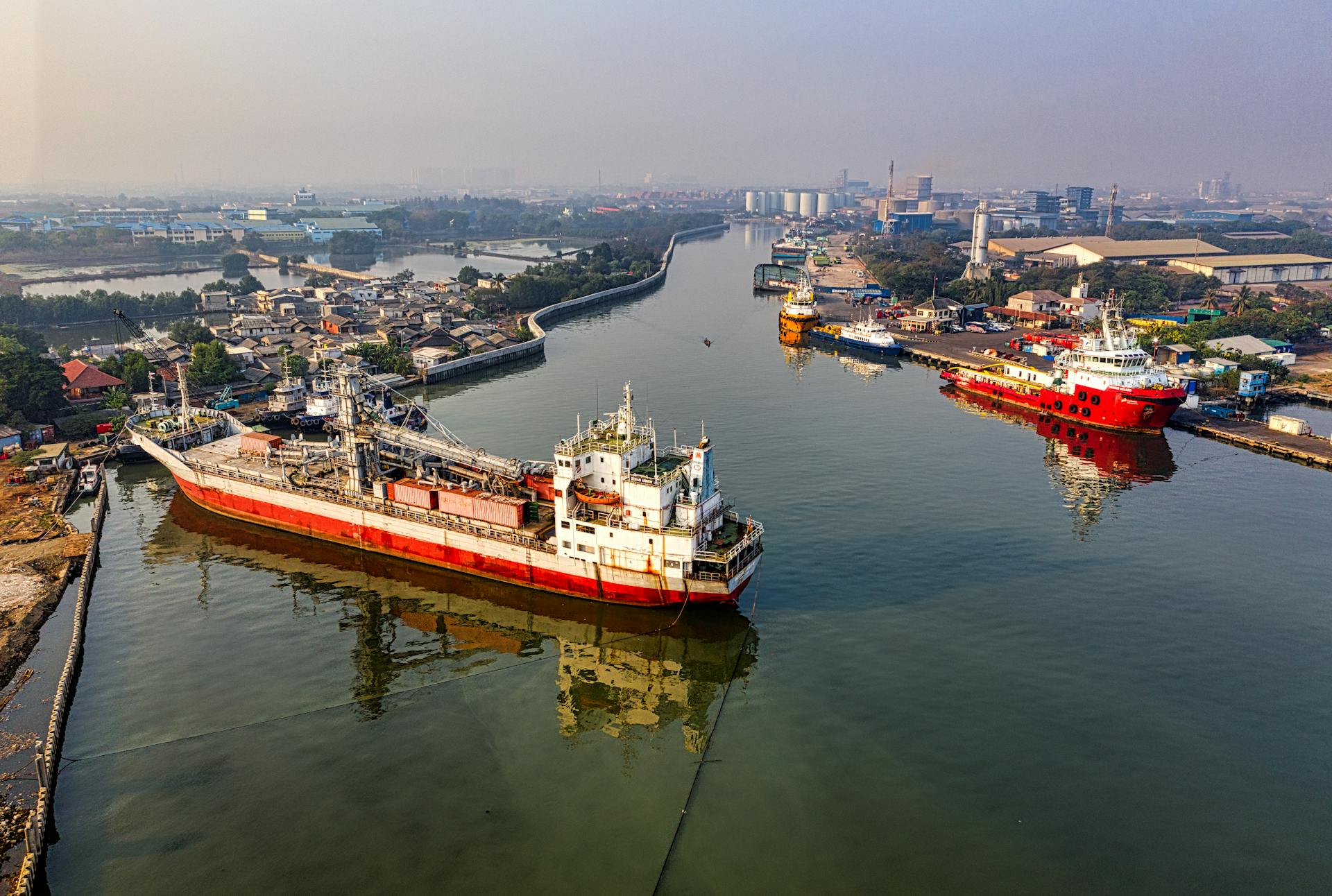 Aerial view of cargo ships docked in Jakarta port, reflecting the bustling commerce of the city.