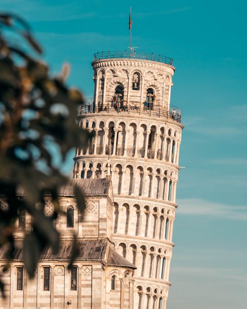 Free Iconic view of the Leaning Tower of Pisa against a clear blue sky, Italy. Stock Photo
