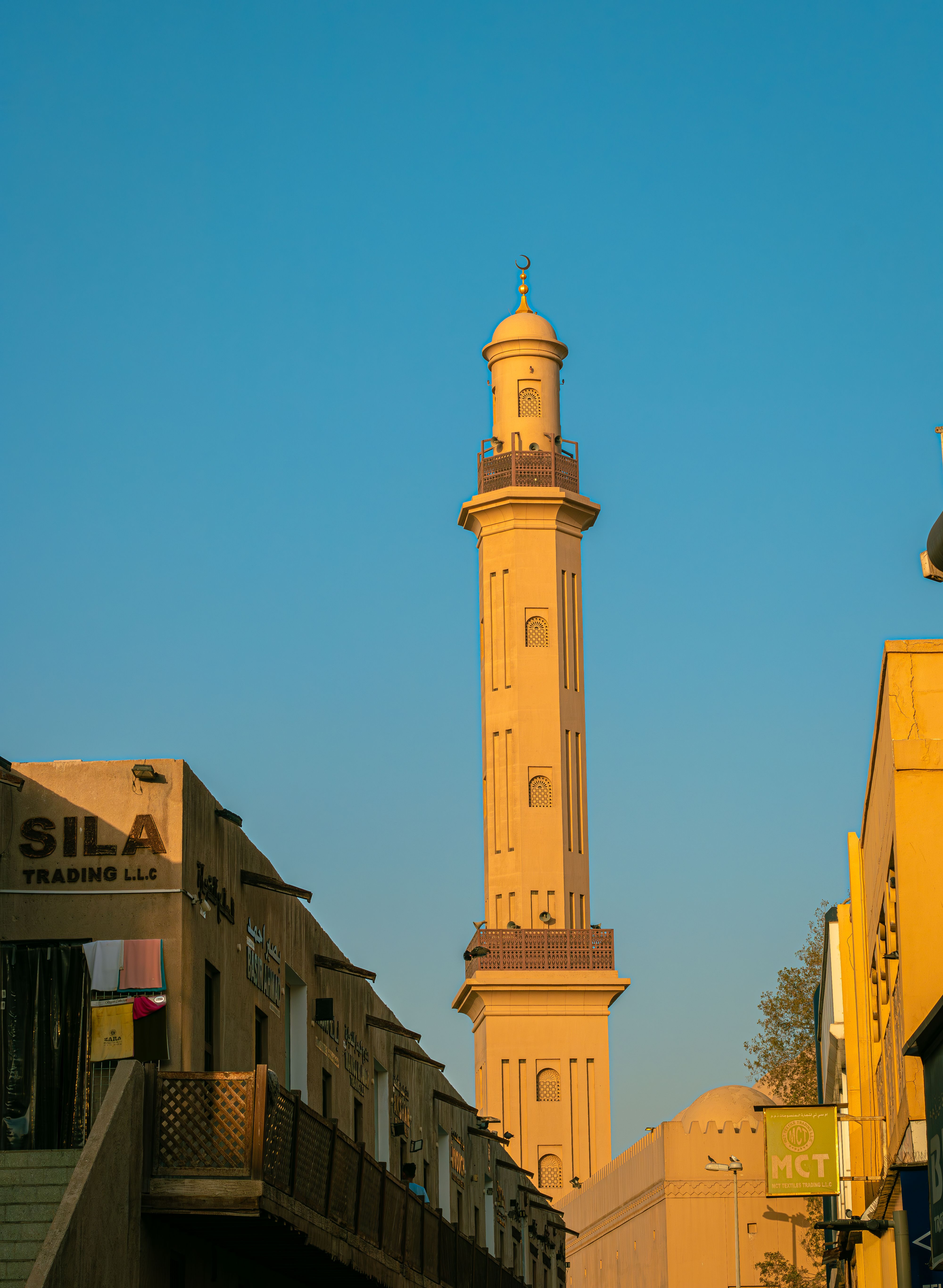 Stunning view of a mosque tower in Dubai, UAE with clear blue sky.