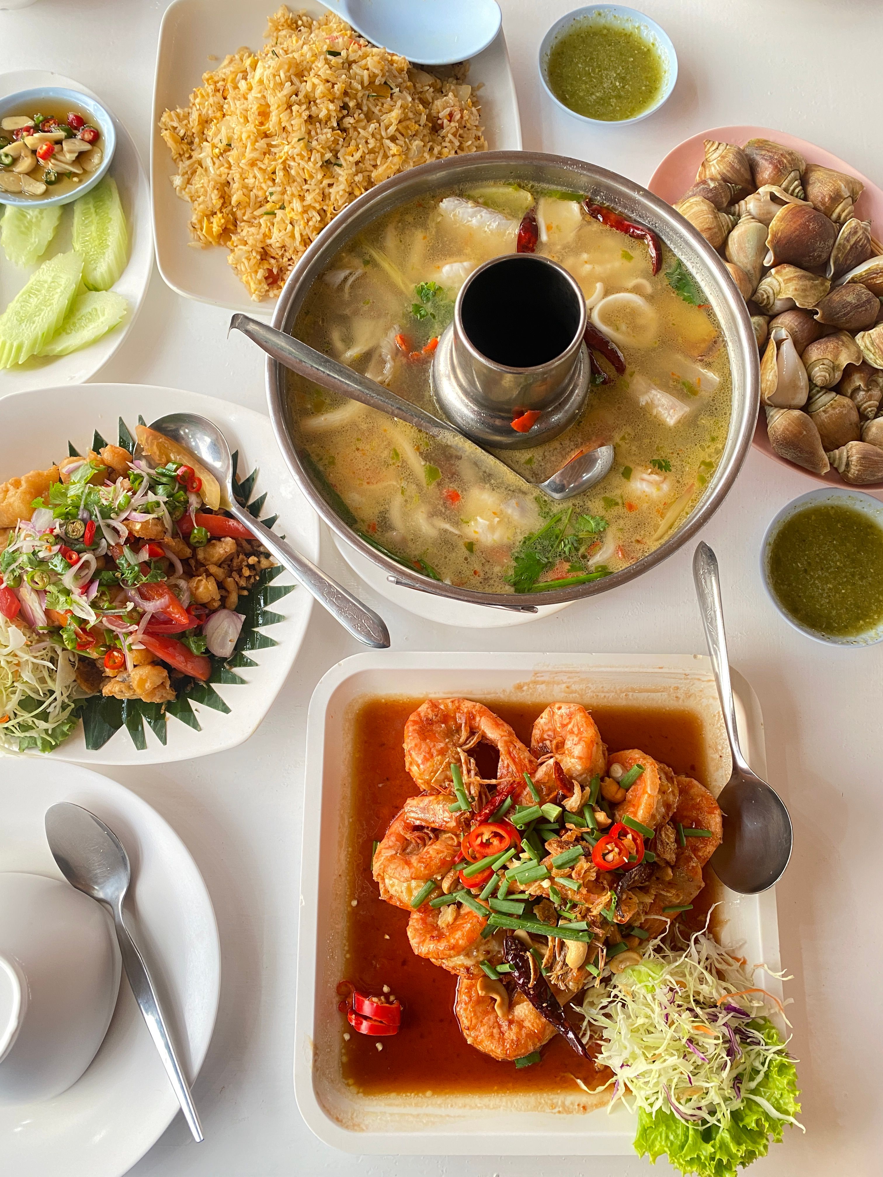 A vibrant spread of traditional Thai dishes including Tom Yum soup, fried rice, seafood and spicy salads.