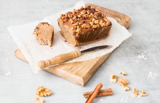 Freshly baked banana bread with walnuts on a wooden board, perfect for delicious homemade treats.