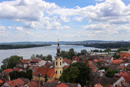 Free Aerial view of Zemun's historic rooftops and the Danube River under a cloudy sky. Stock Photo