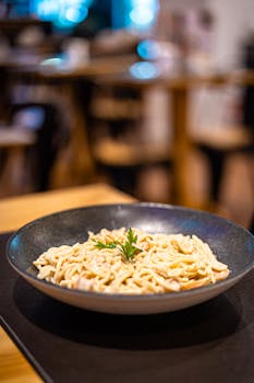 Close-up of creamy pasta served in a restaurant setting, perfect for Italian cuisine enthusiasts.