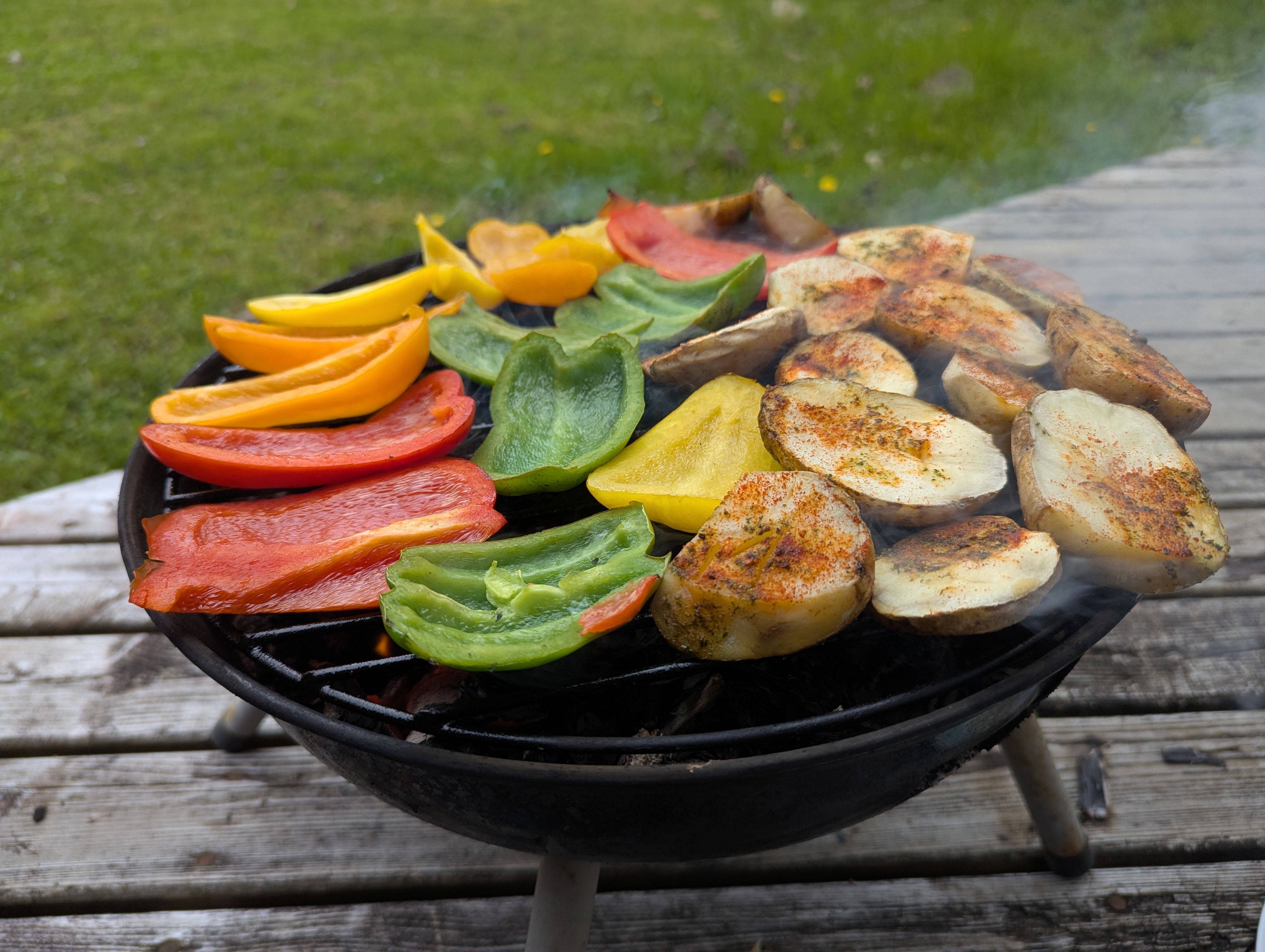 Grilled marinated potatoes arranged on a serving plate with herbs