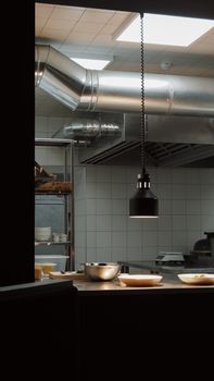Stylish industrial kitchen setup with overhead lighting and modern fixtures.