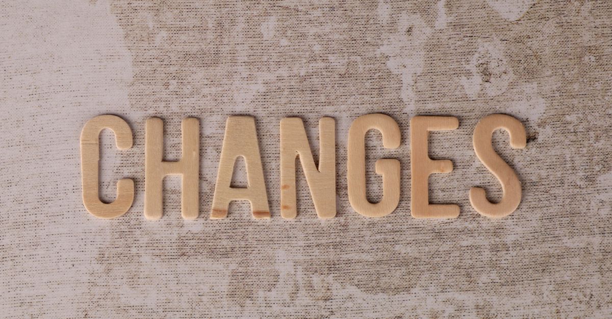 Wooden letters arranged to form 'Changes' on a textured, rustic surface.