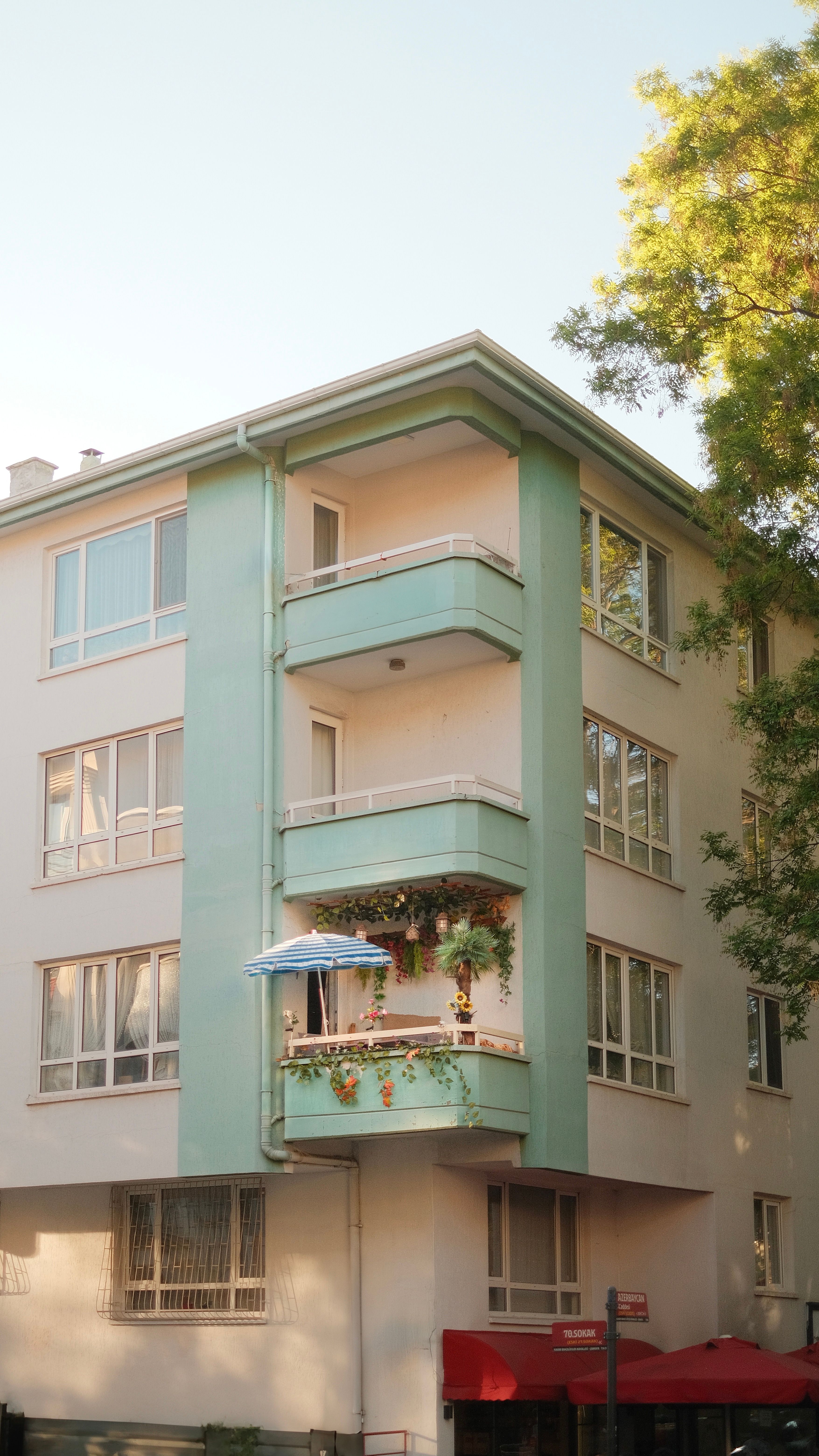 A serene tall residential building with multiple balconies adorned by sunshine.