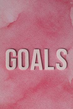 Inspirational pink watercolor background with bold 'Goals' text for motivation.