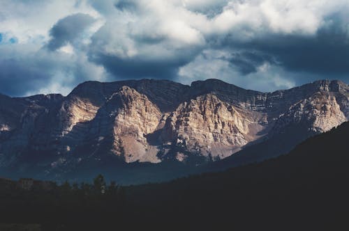 Scenic Photo of Mountain Under Cloudy Sky