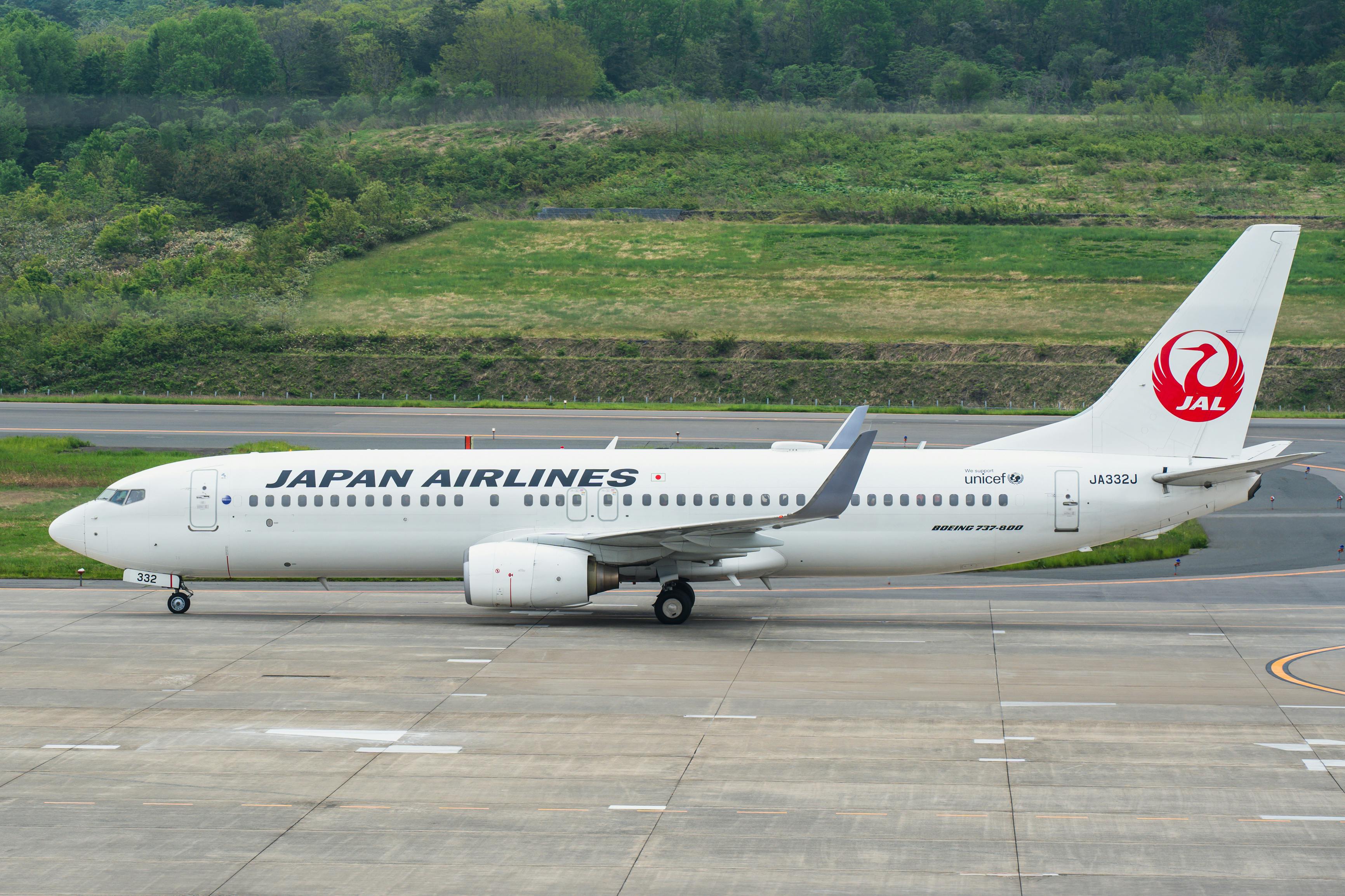 緑豊かな景色の中、滑走路に着陸し離陸の準備を整える日本航空のボーイング 737。 Via Pexels (by Robert Schwarz)