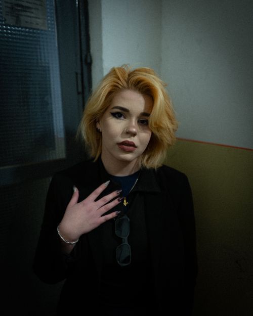 Free A thoughtful portrait of a stylish woman with blonde hair indoors. Stock Photo