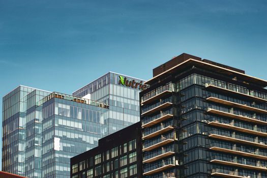 Modern glass office buildings in downtown Saskatoon, photographed on a clear summer day.