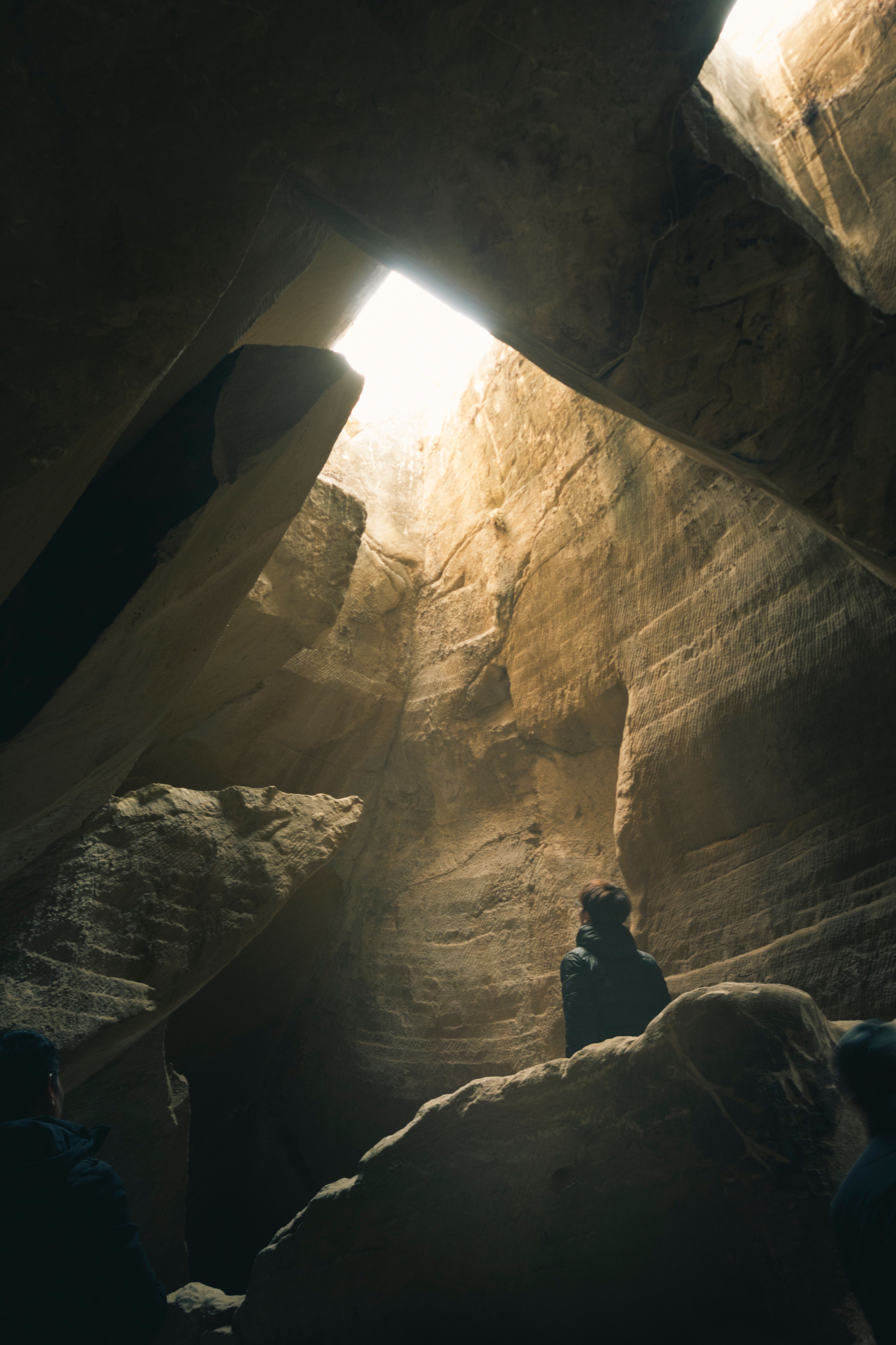 Exploring Sunlit Cave with Steep Walls · Free Stock Photo