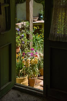A rustic door opens to a vibrant flower-filled garden patio with sunlight streaming in, creating a serene escape.
