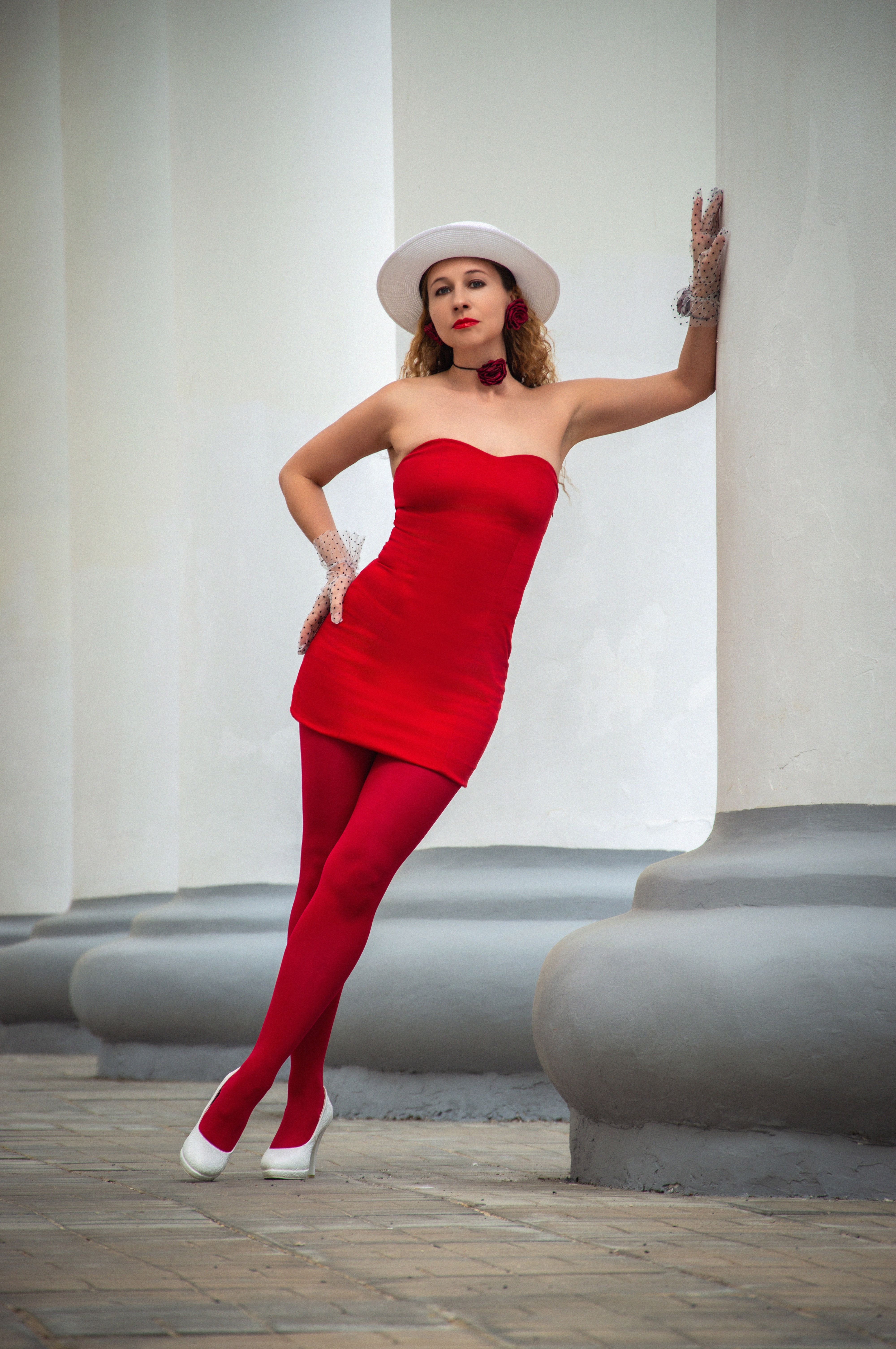 Woman Wearing Black and Red Long-sleeved Mini Dress and Red Leggings in  Front of a Closed White Metal Door  Free Stock Photo
