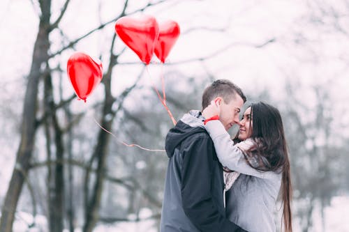 Two People With Heart Shape Balloons in Winter