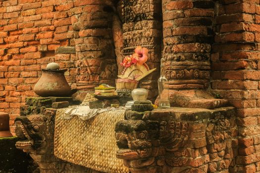 Atmospheric scene of a traditional offering at an ancient Balinese temple, showcasing rich cultural heritage.