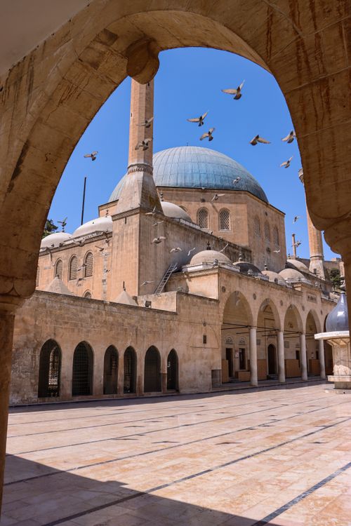 Free Beautiful mosque courtyard in Şanlıurfa with flying pigeons. Stock Photo
