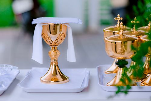 Free Golden chalice used in religious communion ceremony with white cloth napkin. Stock Photo