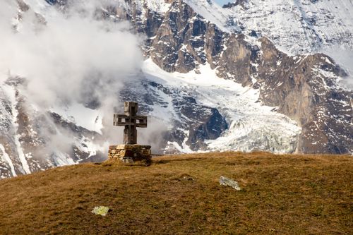 Free A wooden cross in front of majestic alpine mountains in Kärnten, Austria. Stock Photo
