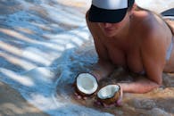 一名妇女在斯里兰卡的热带海滩上喝着椰子汁