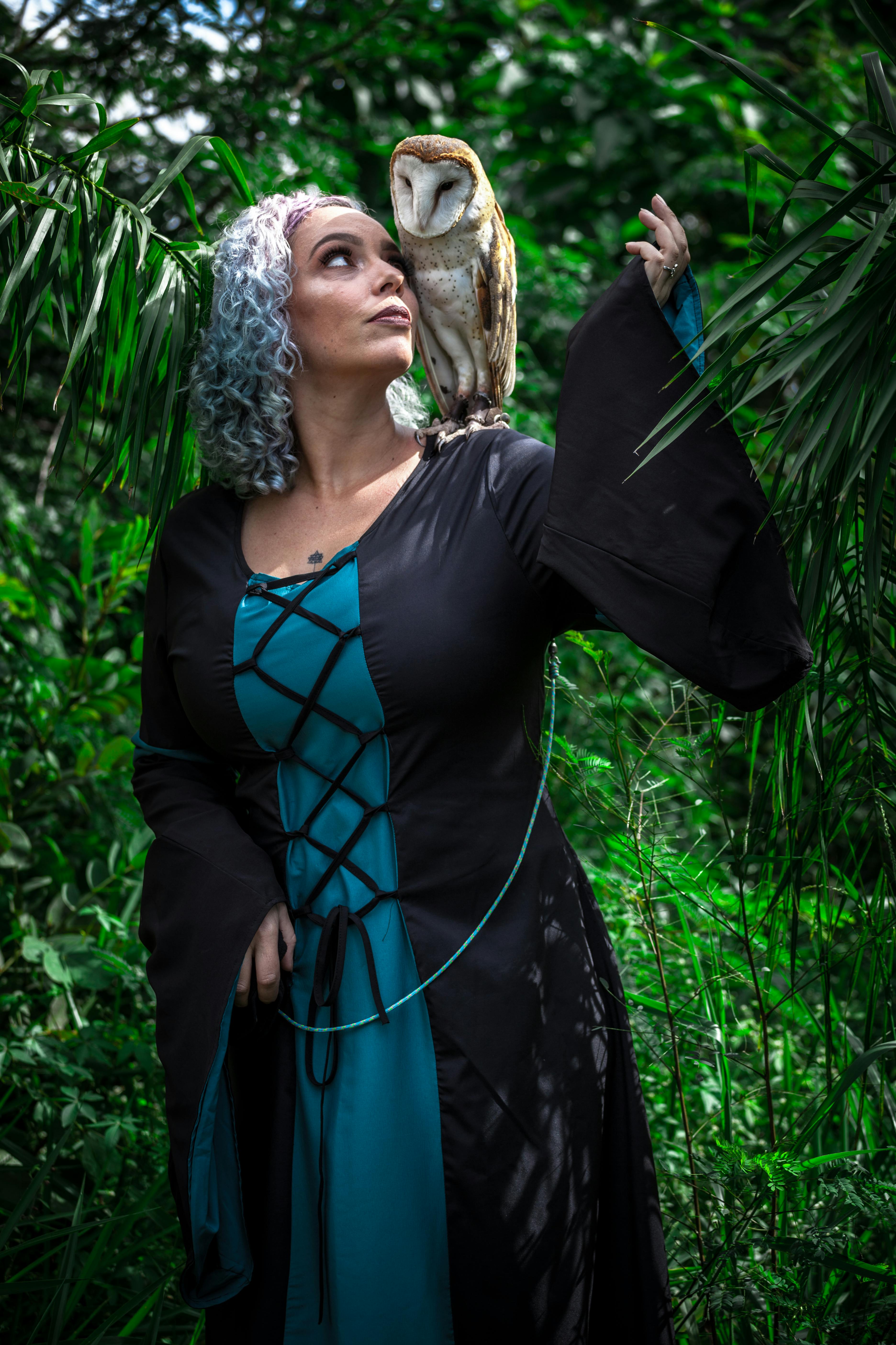 woman standing with barn owl on her shoulder