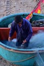 Fisherman Arranging Nets in a Traditional Boat