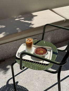 Elegant cafe scene with iced latte and tiramisu under soft sunlight.