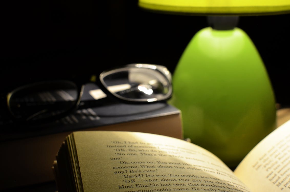 Open Book Page Near Clear Eyeglasses With Black Frames