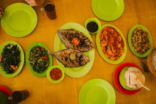 A vibrant spread of traditional Indonesian seafood dishes in Jawa Barat, featuring grilled fish and fresh greens.