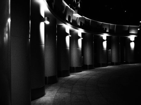 Black and white moody night scene depicting curved architectural columns in Hong Kong.