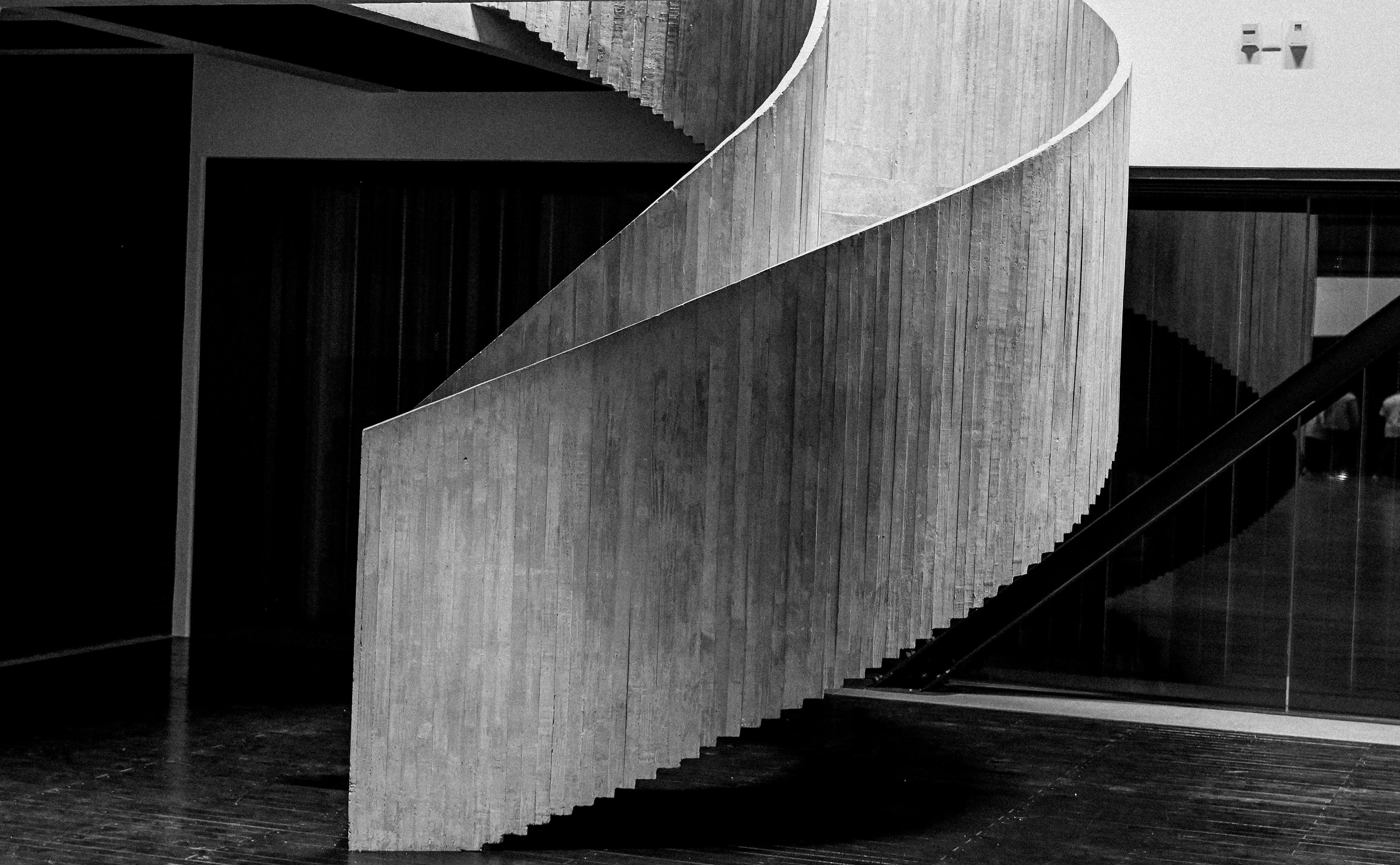 Drewniane schody w nowoczesnym domu z wyraźnymi stopniami i białą ścianą obok