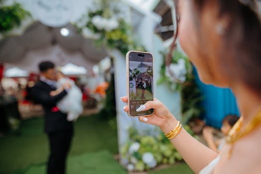 A woman photographs a family moment at an outdoor celebration using a smartphone.