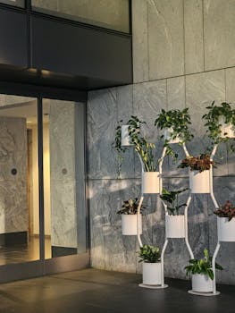 Vertical indoor garden in a modern office lobby with potted plants and natural lighting.