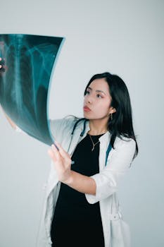 Female doctor examining a chest x-ray in a clinical setting, emphasizing medical professionalism.