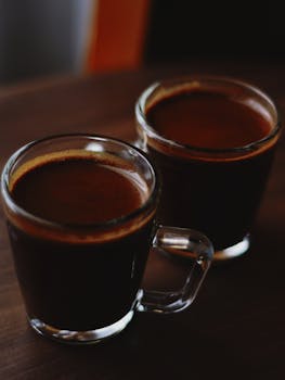 Two cups of rich Arabic coffee in glass mugs create a warm, inviting ambiance.