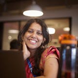 Home 85 Indian businesswoman at office desk, smiling in saree