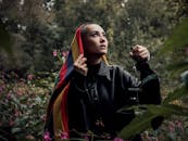 森林里，一位戴着彩色围巾的时尚女子举着灯笼仰望天空