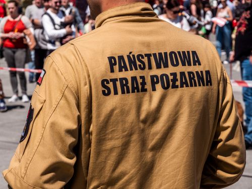 Free A Polish firefighter in uniform at a public event, surrounded by a crowd. Stock Photo