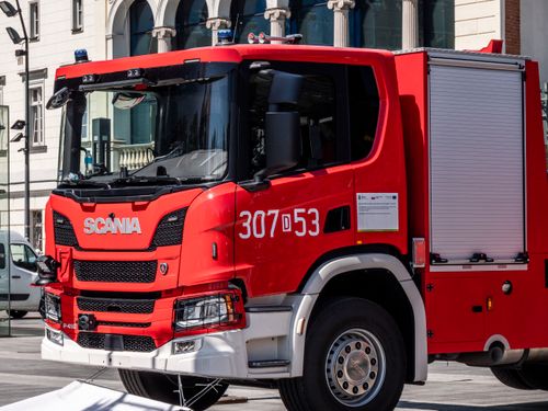 Free Vibrant red fire truck parked in city street during daylight. Stock Photo