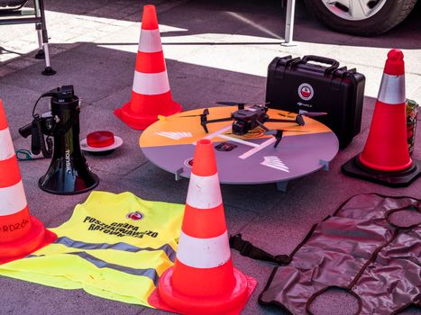 Drone, safety vests, and traffic cones at a construction site, showcasing modern safety and management tools.