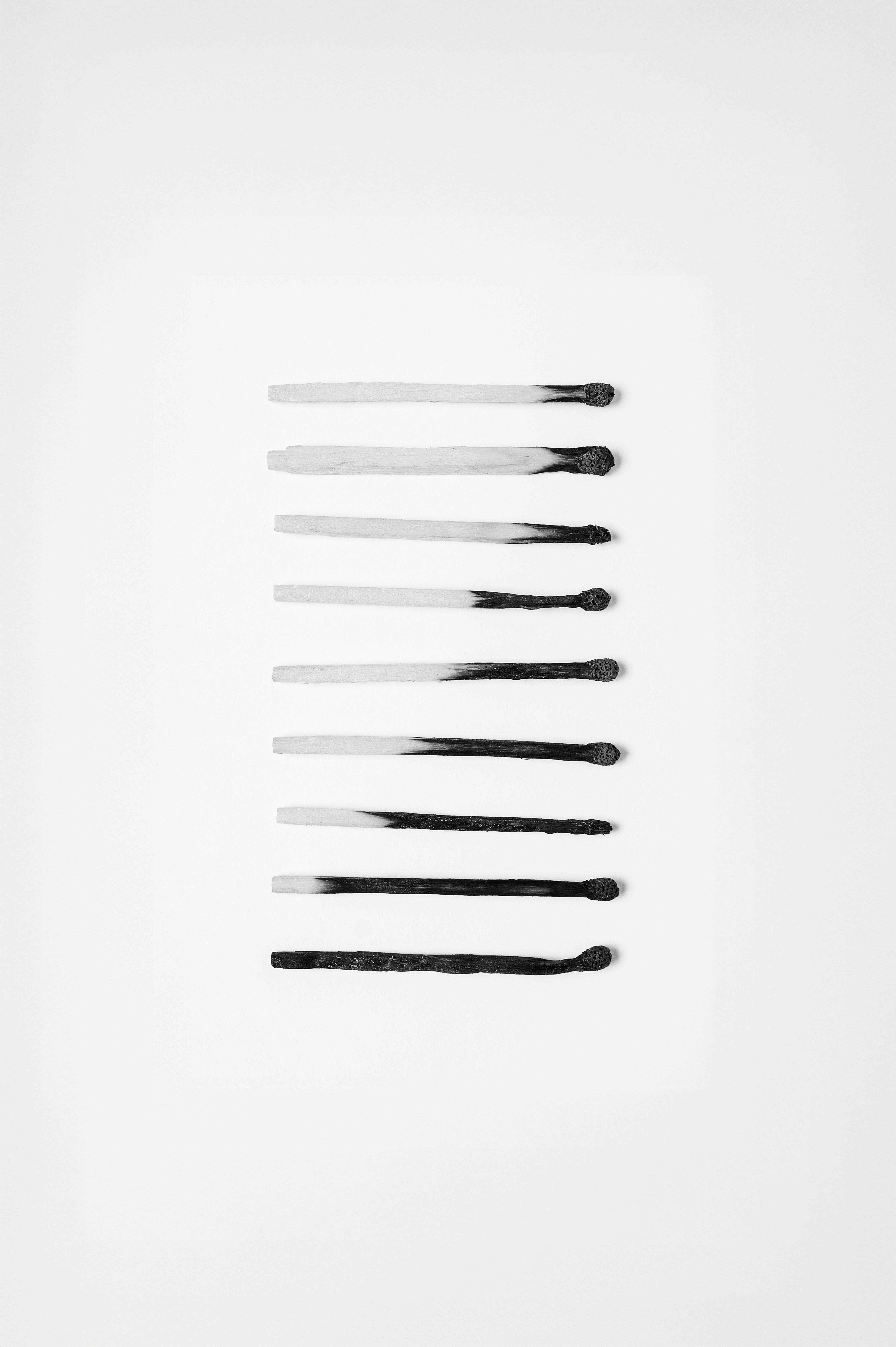 Gratis Disposición abstracta de fósforos quemados que representa la progresión sobre fondo blanco. Foto de stock