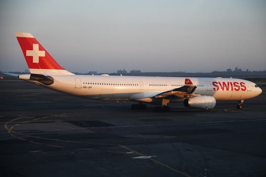 A Swiss International Air Lines Airbus A330 on the tarmac at a New York airport during sunset.