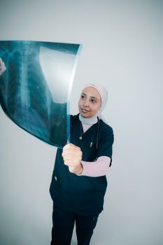 Female doctor analyzing a chest X-ray image with focus and expertise.