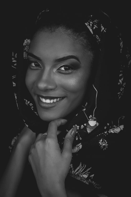 Free Monochrome portrait of a woman in a floral headscarf, smiling confidently at the camera. Stock Photo