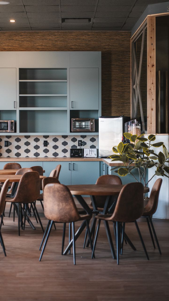 White subway tile backsplash behind a modern office coffee bar counter with coffee supplies