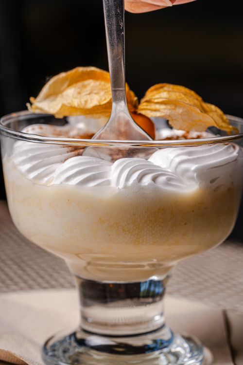 Free Close-up of a creamy dessert topped with a physalis served in a stylish glass goblet. Stock Photo